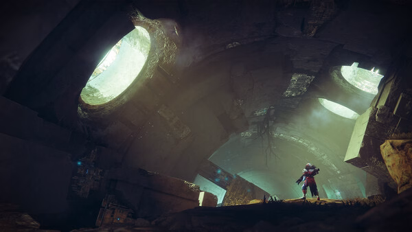 A Destiny 2 screenshot showing a Guardian standing in a mysterious, glowing cavern with large circular openings.