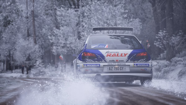 Screenshot from Assetto Corsa Rally shows a rally car speeding through a snowy forest track, kicking up snow behind it.